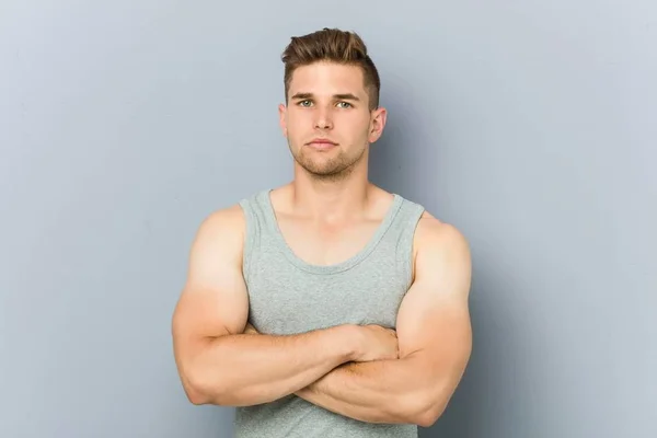 Young fitness man against a wall