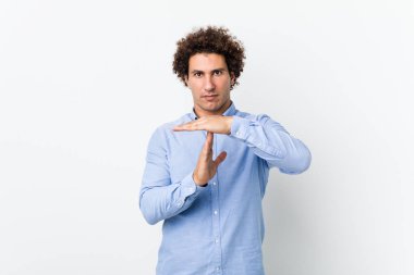 Genç, kıvırcık, olgun bir adam zarif bir gömlek giyiyor..