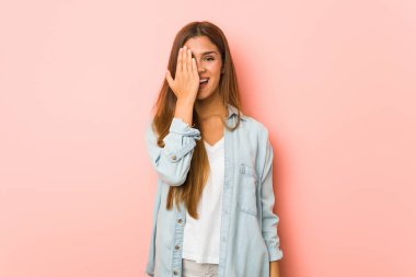 Sıska kadın yüzünün yarısını avuç içiyle kaplayarak eğleniyor..