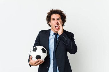 Futbol antrenörü elinde bir top tutarak heyecanla bağırıyor..