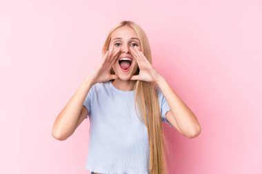 Pembe arka planda genç sarışın kadın heyecanla bağırıyor..