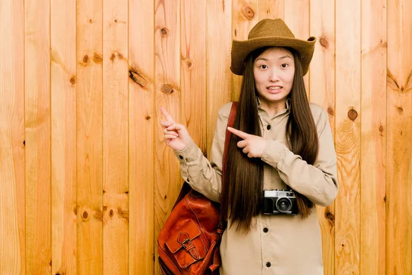 年轻的中国女旅行者震惊地用食指指向一个复制的空间 — 图库照片