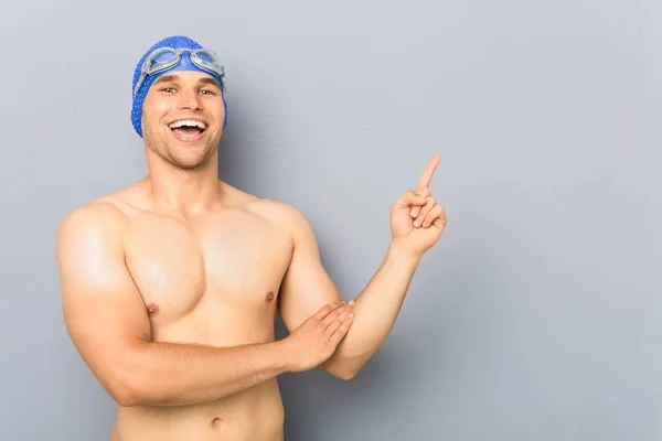 Mladý Profesionální Plavec Muž Veselým Úsměvem Ukazuje Ukazováčkem Pryč — Stock fotografie