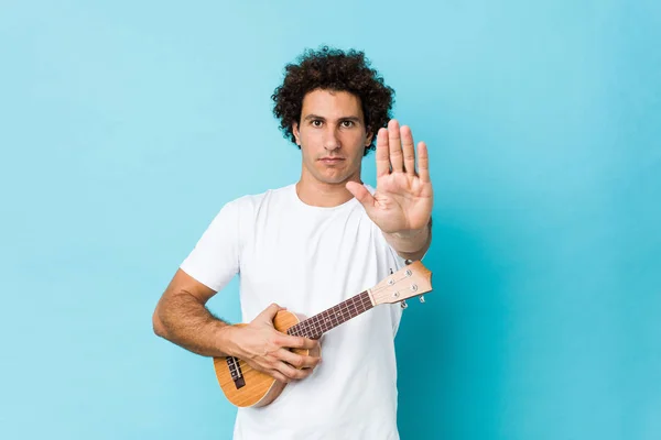 Young Caucasian Curly Man Playing Ukelele Standing Outstretched Hand Showing — Stock Photo, Image