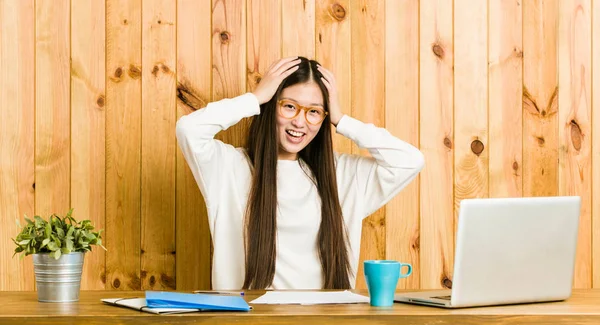 Jovem Chinesa Estudando Sua Mesa Alegremente Mantendo Mãos Cabeça Conceito — Fotografia de Stock