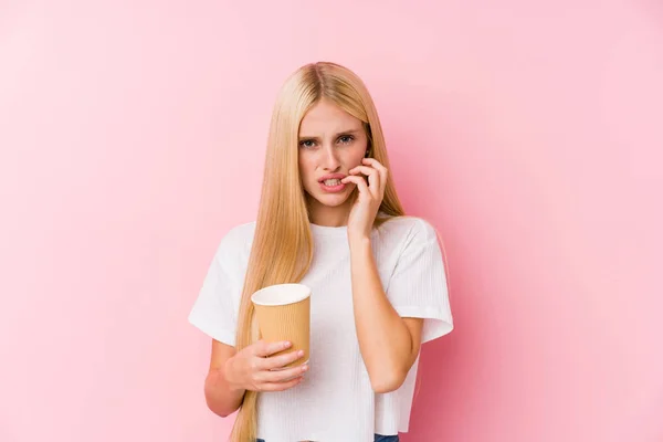 Ung Blond Jente Som Holder Kaffe Som Biter Negler Nervøs – stockfoto