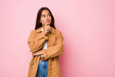 Genç melez Hintli kadın şüpheli ve kuşkulu bir ifadeyle yanlamasına bakıyor..