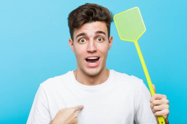 Kafkasyalı genç bir adam sineklik tutarken kendini göstererek şaşırdı ve gülümsedi..