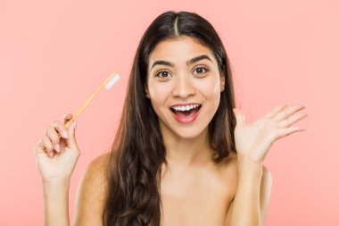 Zaferi ya da başarıyı kutlayan bir diş fırçası tutan genç Hintli kadın.