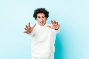 Mavi arka planda genç sporcu kameraya sarıldığı için kendinden emin hissediyor..