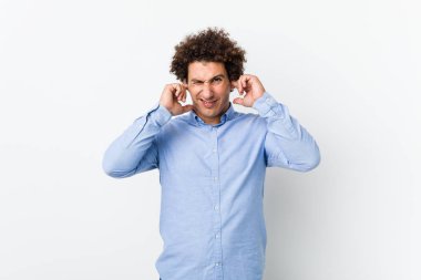 Genç, kıvırcık, olgun bir adam. Zarif bir gömlek giyiyor. Kulaklarını elleriyle kapatıyor..