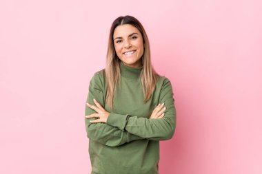 Kendini güvende hisseden, kararlılıkla kollarını kavuşturan beyaz bir kadın..