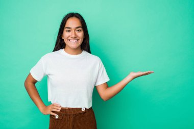 Genç melez Hintli kadın avucunun içinde bir kopya alanı gösteriyor ve belinde bir el daha tutuyor..