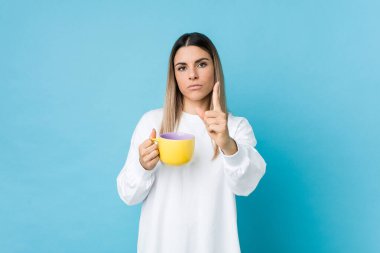 Kafkasyalı genç bir kadın elinde kahve fincanı tutuyor..