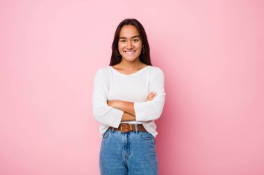 Kendine güveni tam genç bir Hintli kadın, kararlılıkla kollarını kavuşturuyor..