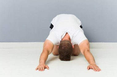Genç beyaz adam yoga pratik germe.
