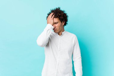 Genç, kıvırcık, olgun bir adam zarif bir gömlek giyip bir şeyi unutuyor. Alnına avuç içi ve gözlerini kapatıyor..