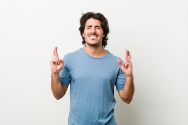 Beyaz bir geçmişi olan genç yakışıklı adam şans dilemek için parmaklarını çaprazladı.