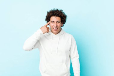 Mavi arka planda genç bir sporcu işaret parmağıyla bir hayal kırıklığı gösteriyor..