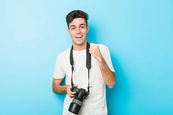 Young Caucasian Photographer Man Holding Camera Cheering Carefree Excited Victory — Stock Photo, Image