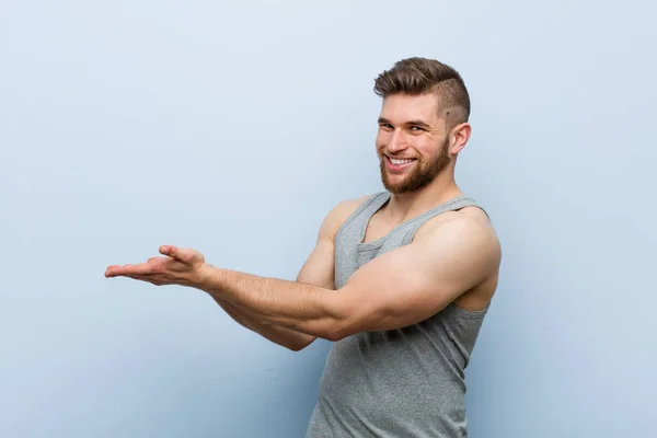 Mladý Pohledný Fitness Muž Drží Kopii Prostoru Dlani — Stock fotografie