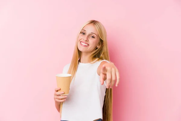 年轻的金发姑娘拿着外卖咖啡开心地微笑着 指着前面 — 图库照片