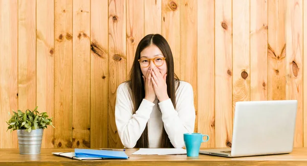 Jovem Chinesa Estudando Sua Mesa Rindo Algo Cobrindo Boca Com — Fotografia de Stock