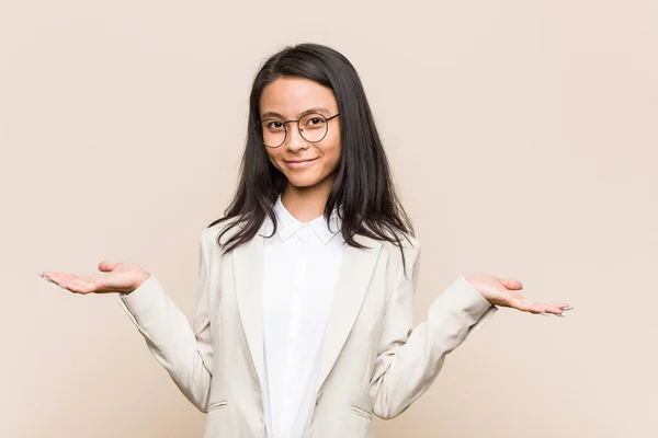 Young business chinese woman showing a welcome expression.