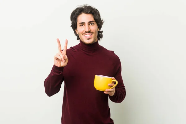 Joven Caucásico Sosteniendo Una Taza Café Mostrando Número Dos Con — Foto de Stock