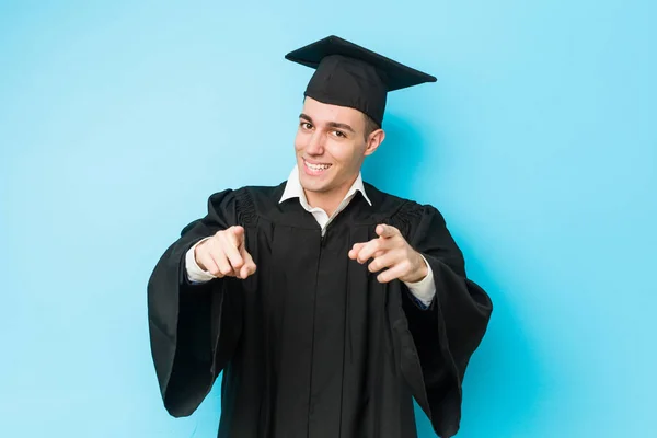 Junger Kaukasischer Hochschulabsolvent Lächelt Fröhlich Und Zeigt Nach Vorne — Stockfoto