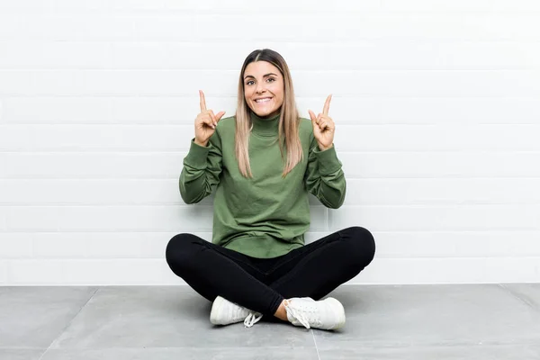 Young Caucasian Woman Sitting Floor Indicates Both Fore Fingers Showing — 스톡 사진