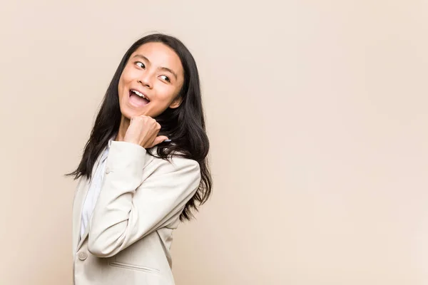 Young Business Chinese Woman Points Thumb Finger Away Laughing Carefree — ストック写真