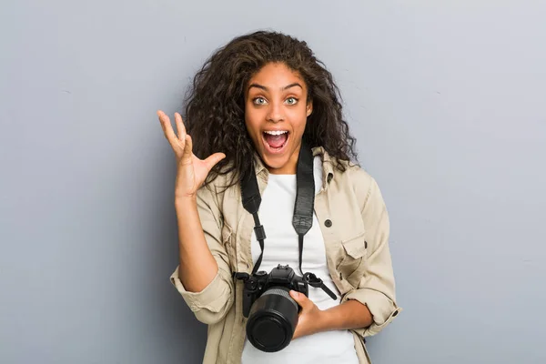 勝利や成功を祝うカメラを持っている若いアフリカ系アメリカ人の写真家の女性 — ストック写真