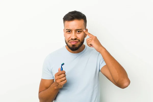 Young South Asian Man Holding Razor Blade Showing Disappointment Gesture — Stockfoto