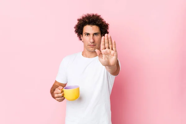 Joven Hombre Rizado Caucásico Sosteniendo Una Taza Pie Con Mano — Foto de Stock