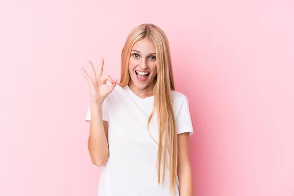 Ung Blond Kvinna Rosa Bakgrund Blinkar Ett Öga Och Håller — Stockfoto