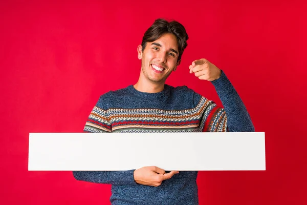 Joven Sosteniendo Cartel Sonrisas Alegres Apuntando Hacia Adelante — Foto de Stock