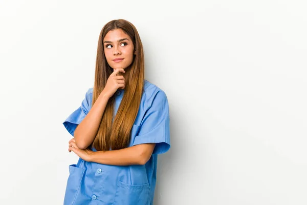 Νεαρή Λευκή Νοσοκόμα Κοιτάζει Πλάγια Αμφίβολη Και Σκεπτικιστική Έκφραση — Φωτογραφία Αρχείου