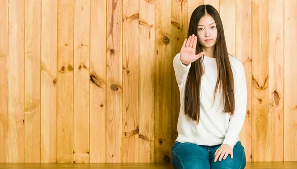 Jovem Chinesa Sentada Lugar Madeira Com Mão Estendida Mostrando Sinal — Fotografia de Stock
