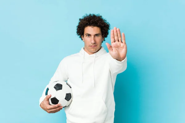 Sportowy Mężczyzna Trzymając Piłkę Nożną Stojącą Wyciągniętą Ręką Pokazuje Znak — Zdjęcie stockowe