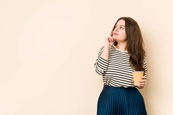 Jovem Mulher Curvilínea Segurando Café Olhando Para Lados Com Expressão — Fotografia de Stock