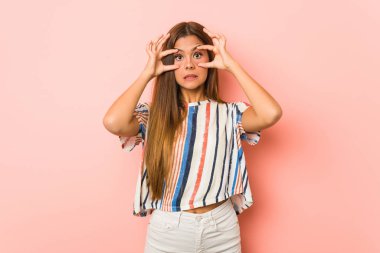 Young slim woman keeping eyes opened to find a success opportunity.