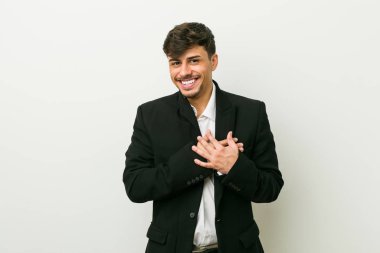 Genç İspanyol iş adamı dost canlısı bir ifadeye sahip, avuçlarını göğsüne bastırıyor. Aşk konsepti.