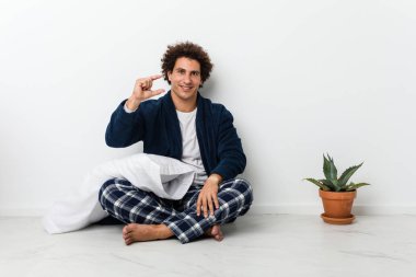 Küçük bir şey tutuyor, gülümsüyor ve kendinden emin..