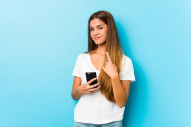 Kafkasyalı bir kadın elinde telefonla seni işaret ediyor. Sanki seni davet ediyormuş gibi..
