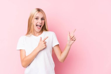 Pembe arka planda genç sarışın kadın işaret parmaklarıyla fotokopi alanını işaret ederek heyecan ve arzusunu ifade ediyor..