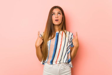 Genç, sıska bir kadın, ağzı açık, üst tarafı işaret ediyor..