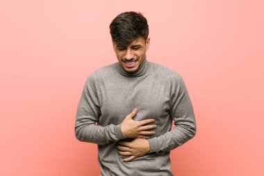 Young smart student man sick, suffering from stomachache, painful disease concept.