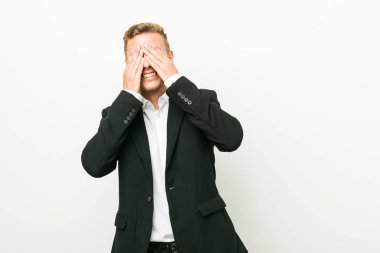 Kafkasyalı genç iş adamı elleriyle gözlerini kapatıyor, geniş bir gülümsemeyle bir sürpriz bekliyor..