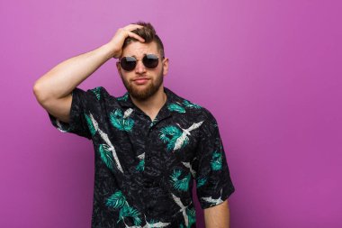 Young man wearing a vacation look being shocked, he has remembered important meeting.